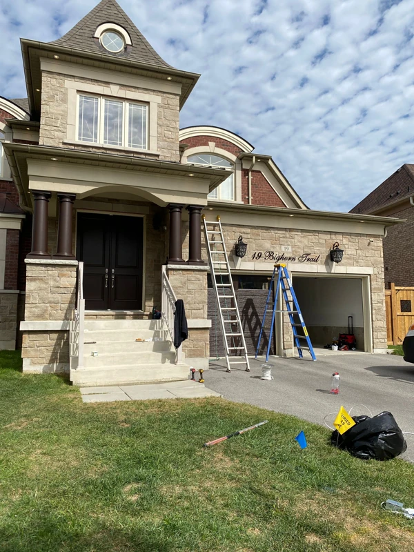 Ladders and installation equipment outside a stone and brick home